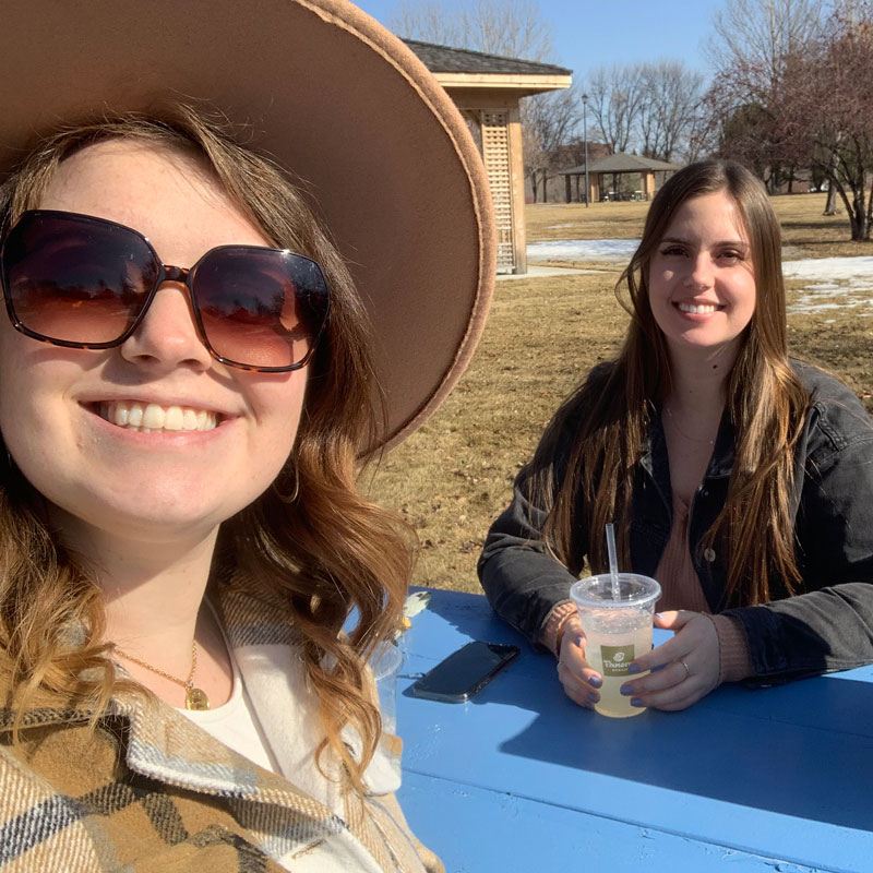 Two girls at the park eating lunch while out Exploring Grand Forks 2 girls sitting at the park enjoying the nice weather and their lunch while exploring Grand Forks, ND