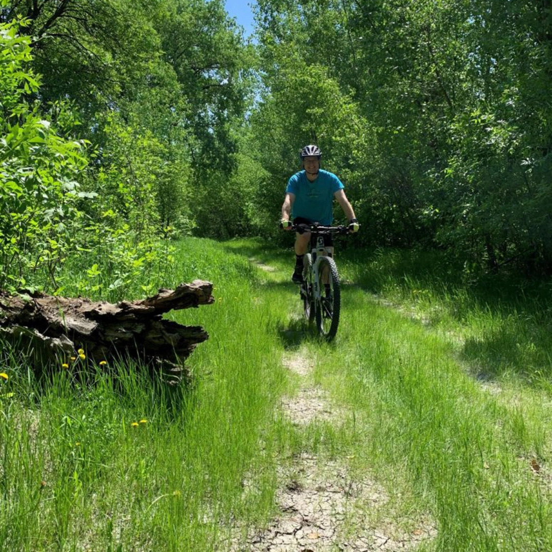 biking-in-grand-forks Man bikes on Grand Forks Greenway on summer day