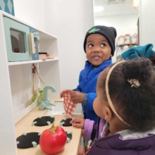 Two kids play with toy kitchen in Grand Forks, ND small shop