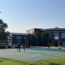 Hoops Haven Photo 3 Slider Three people play basketball on the basketball court near the UND Student Wellness Center
