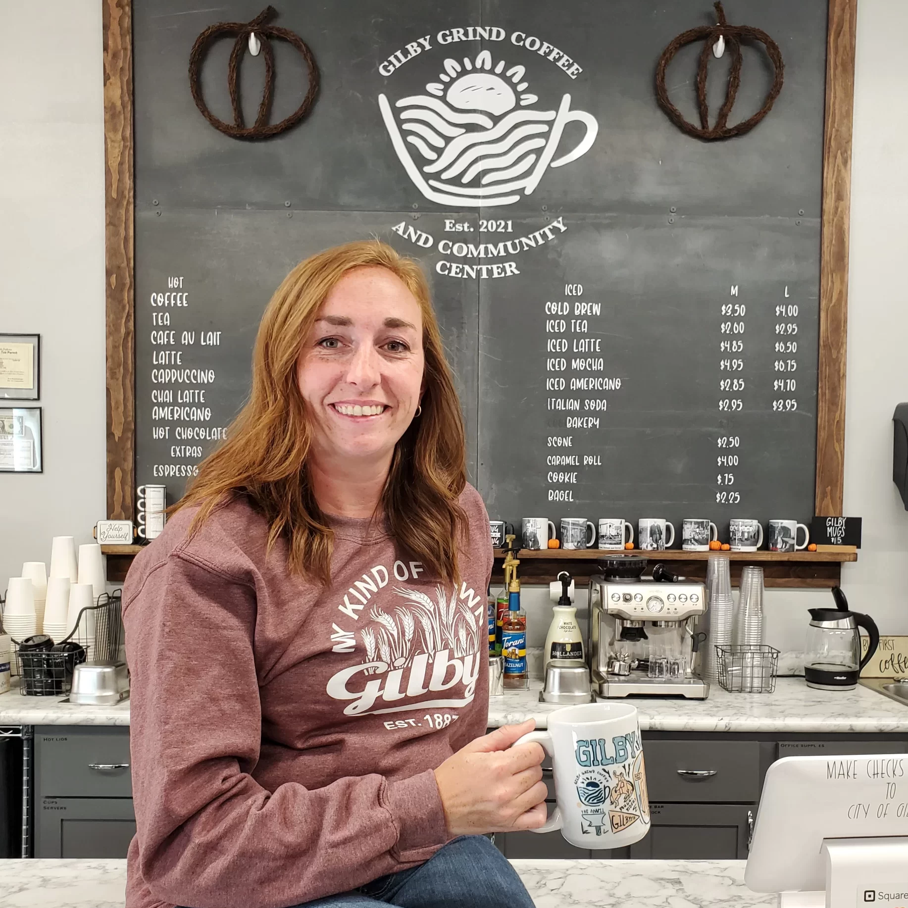 Gilby-Grind-Coffee-Grand-Forks-County What's Cooler Today? Article author Kayla sits with a cup of coffee in a Gilby Coffee Shop