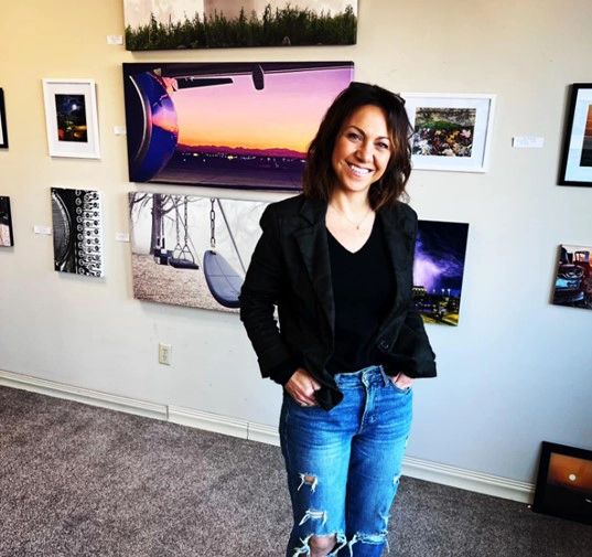 art-for-vets Woman stands in front of art work at Art for Vets event in Grand Forks.