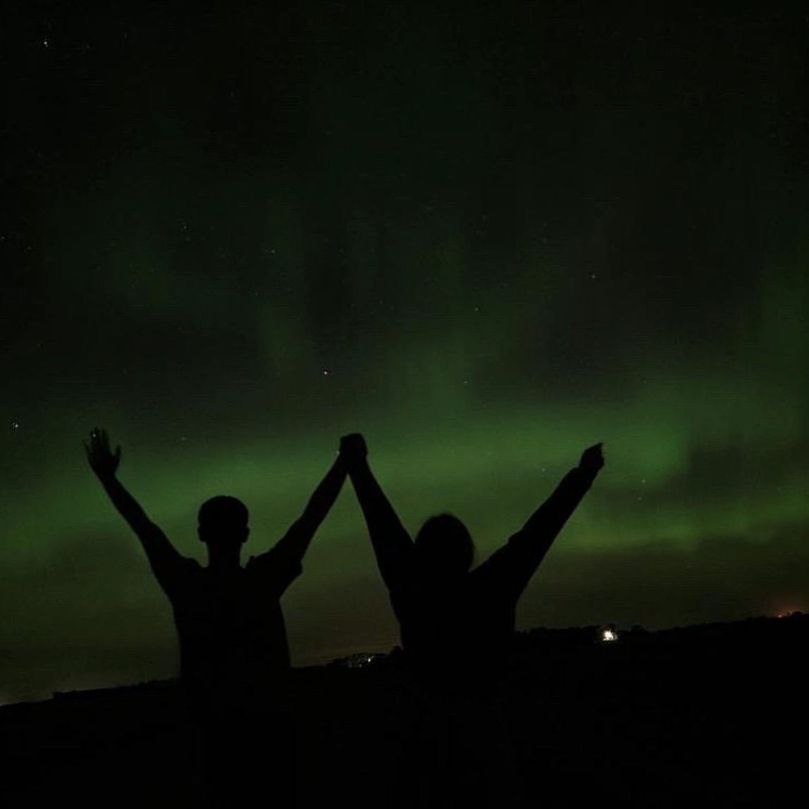 northern-lights-jenna-westpfahl-CREDIT Two people holding hands watching the northern lights in Grand Forks.