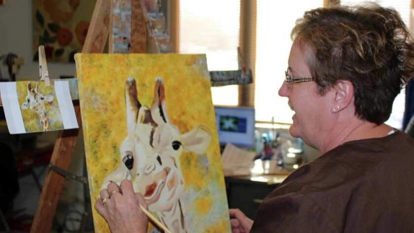 oil-painting Woman oil painting a yellow picture of a giraffe in Grand Forks.
