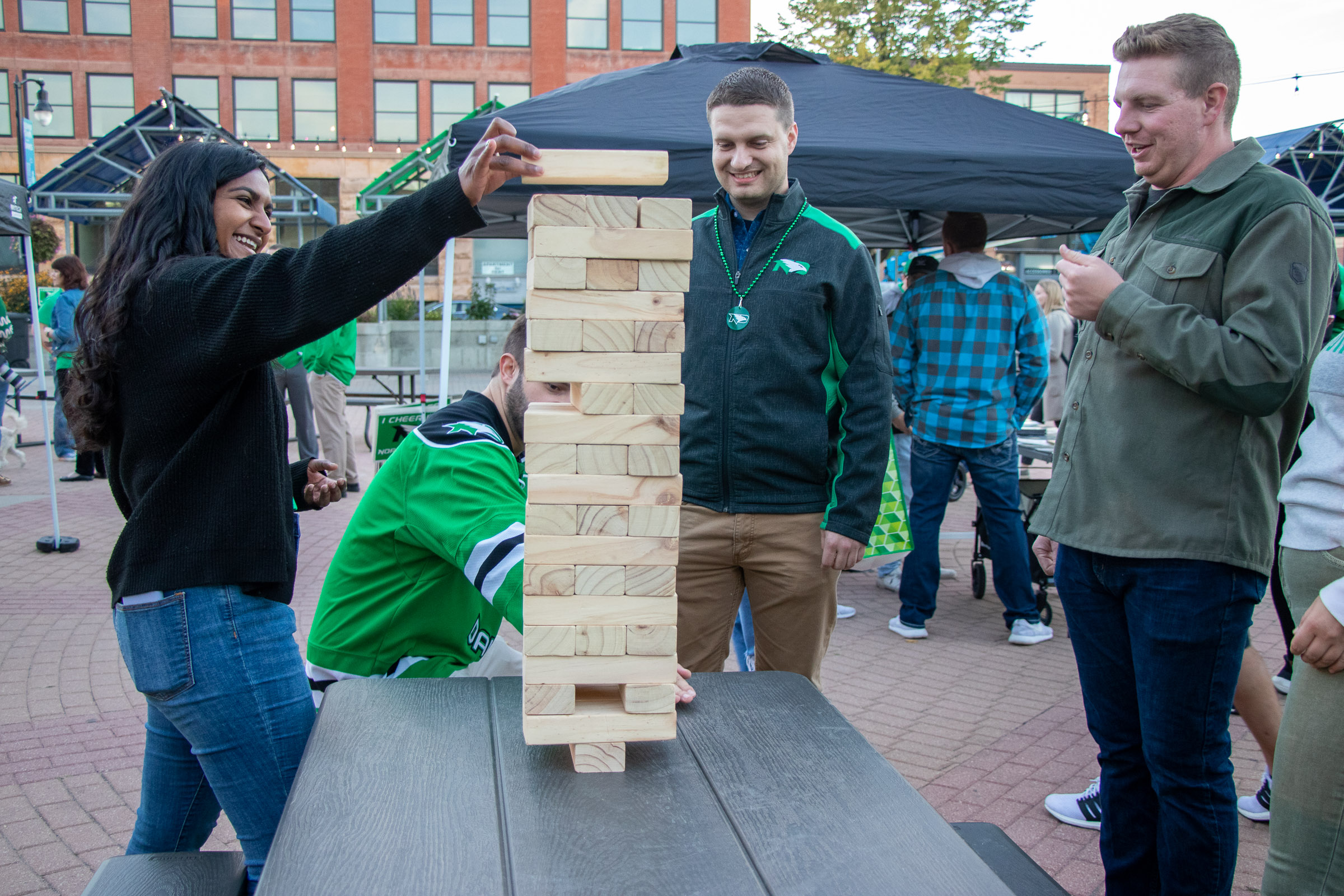 Grand Forks Tourist Destinations - Town Square Four people, including WCT writer Paul, gather around a picnic table in Grand Forks Town Square to play an oversized game of Jenga.
