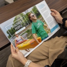 Grand Forks Relocation Guide Two hands are pictured holding a spread within the Grand Forks Relocation Guide.