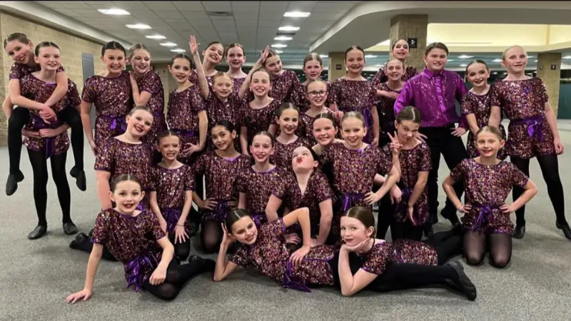 Grand-Forks-Dance-Team A Grand Forks Dance Team poses for a picture with vibrant purple costumes on.