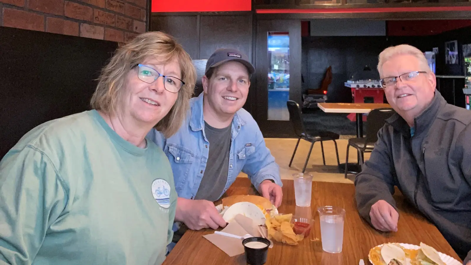 Grand-Forks-Red-Pepper 3 people sit at Grand Forks Red Pepper with Food smiling at the camera