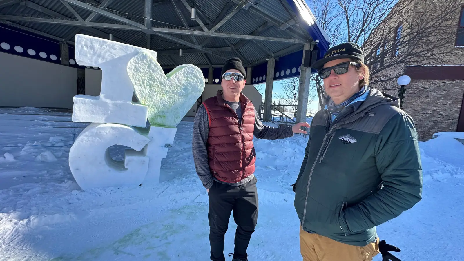 Grand-Forks-Town-Square-I-LOVE-GF Grand Forks Author Paul stands with friend in Townsquare next to ice sculpture that reads "I Love Grand Forks"