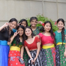Grand Forks Culture A group of seven young women smile at the camera dressed in colorful, traditional Nepalese garments.