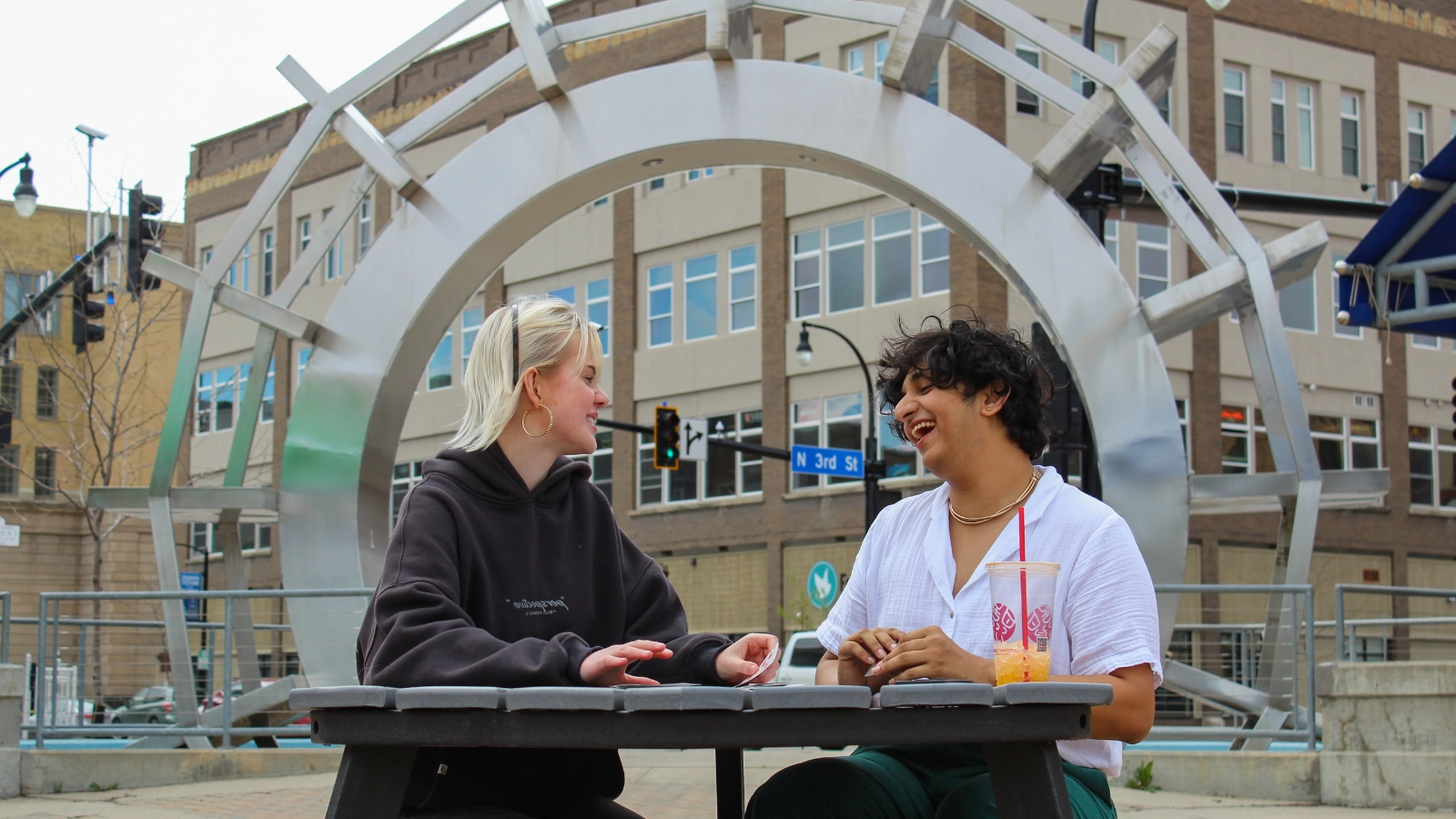 summer-in-grand-forks-jay-and-friend Jay and friend sit in Town Square in Grand Forks.