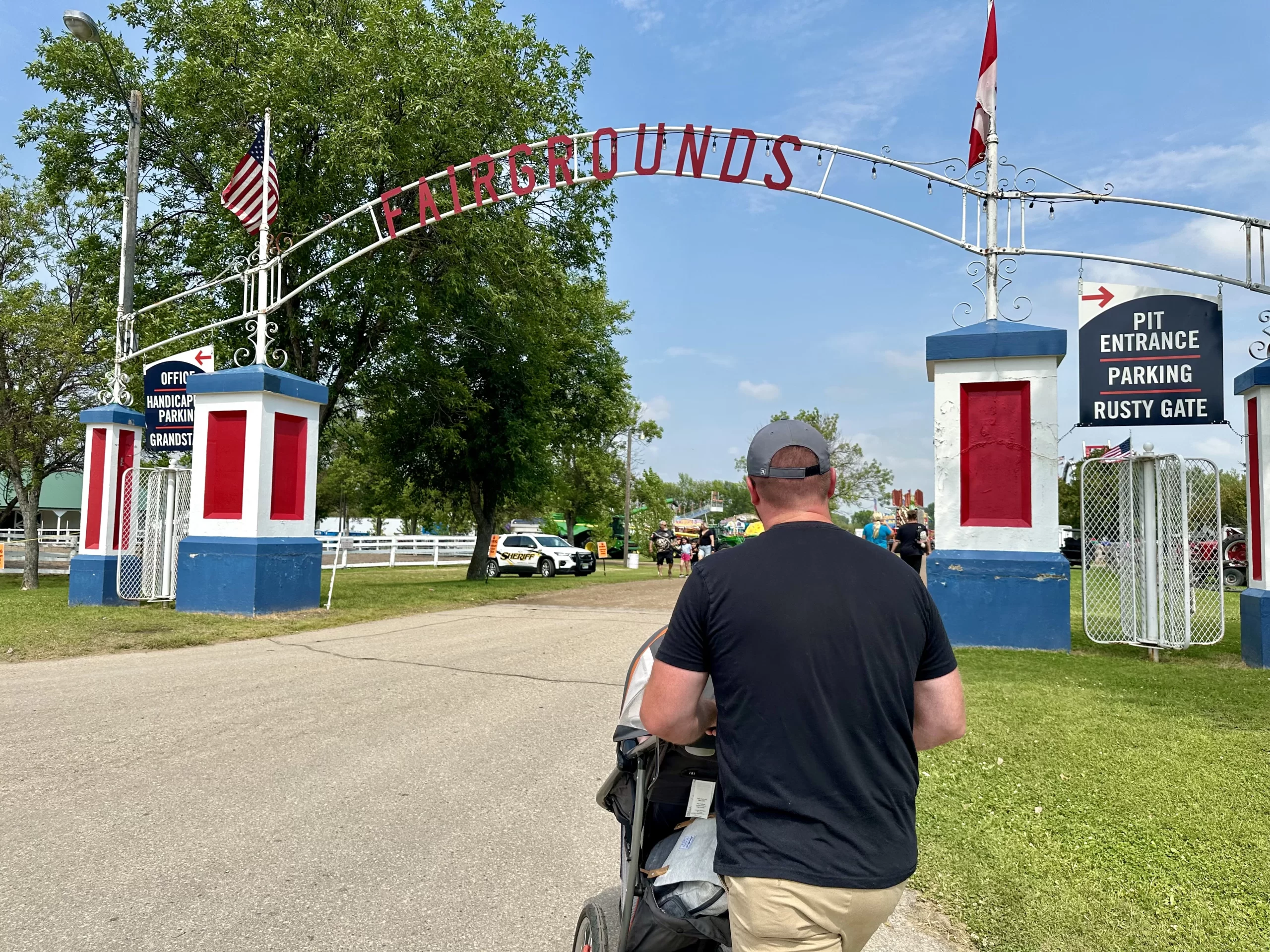 day-trips-from-grand-forks Dad pushing a stroller into the Fairgrounds near Grand Forks.