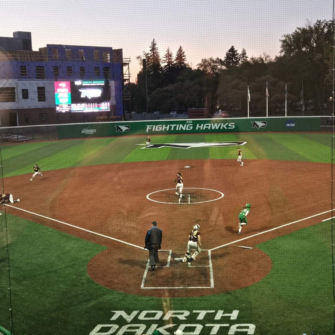 UND Athletics - Albrecht Field A softball game at Albrecht Field plays on at dusk. In the background is the large scoreboard as well as the framing of the new apartment complex being built near the field.