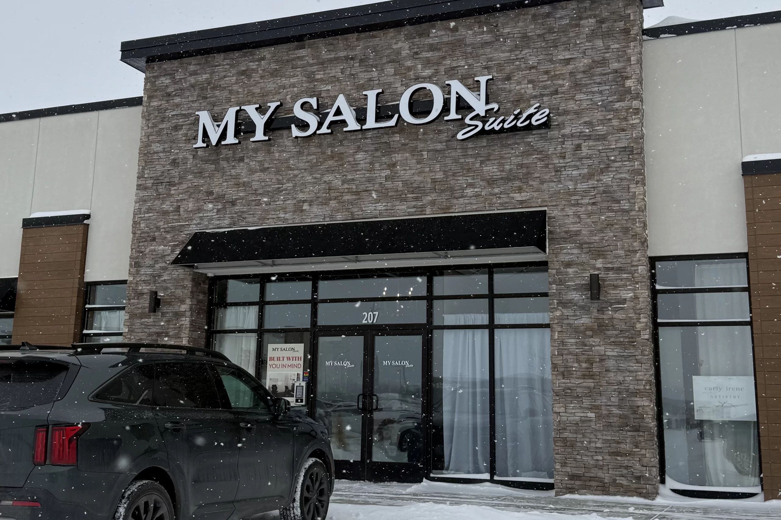 Grand Forks Glow Up Hair A tan brick exterior of a storefront that reads "My Salon Suite".