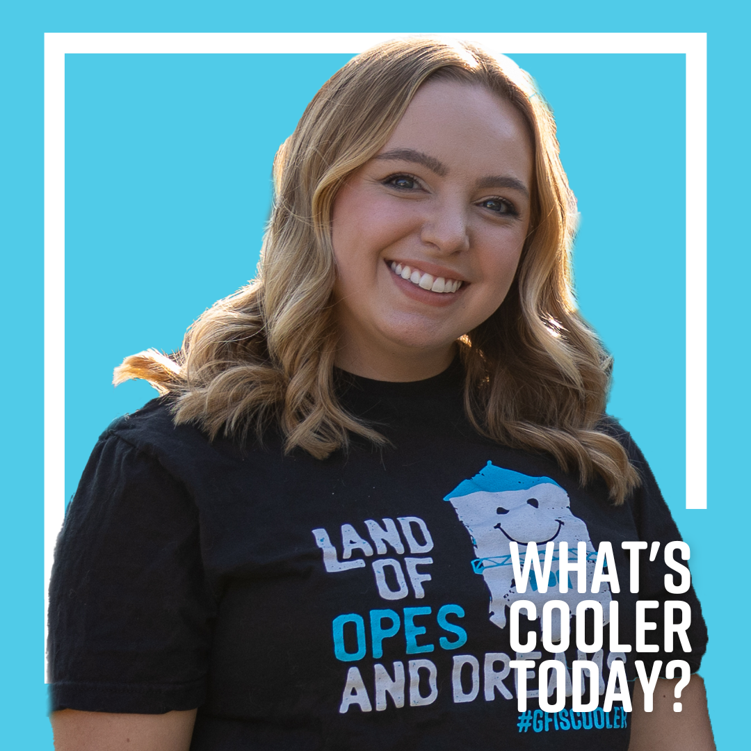 Brenna Cooler Headshot What's Cooler Today author Brenna smiles in her Cooler merch on front of a blue graphic that reads "What's Cooler Today"