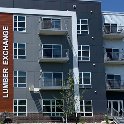 lumber exchange Exterior of Lumber Exchange apartments. Gray siding with loads of small windows and small balconies as well.
