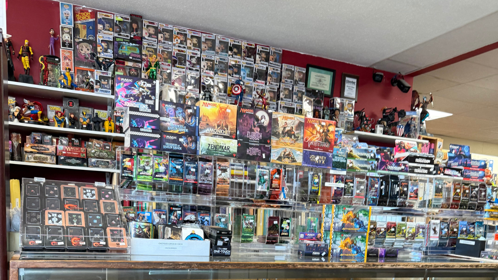 This image is of the display case behind the checkout at another gaming store. Shown are dozens of games and cards and accessories perfect for any gamer.