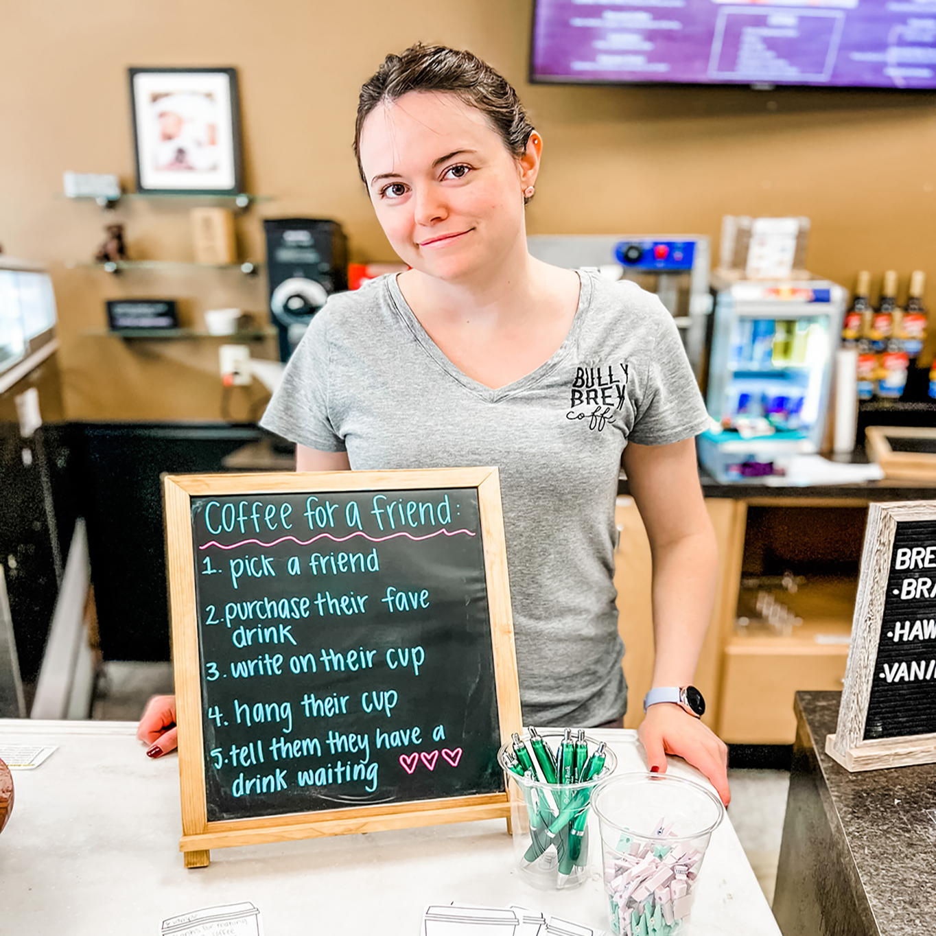 Bully Brew Employee Photo Bully Brew Employee poses with their sign that describes their pay it forward movement.