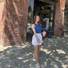 Natalie Lund Feature Image author Natalie poses in front of the Urban Stampede coffee spot
