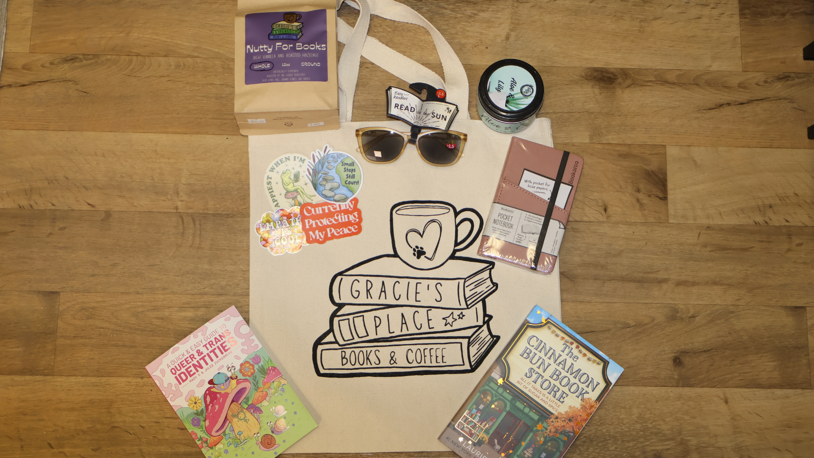 Gracie's Place Flat Lay Gracie's Place goodies displayed in a flat lay. A tote bag and a few cozy reads with their store stickers around too!