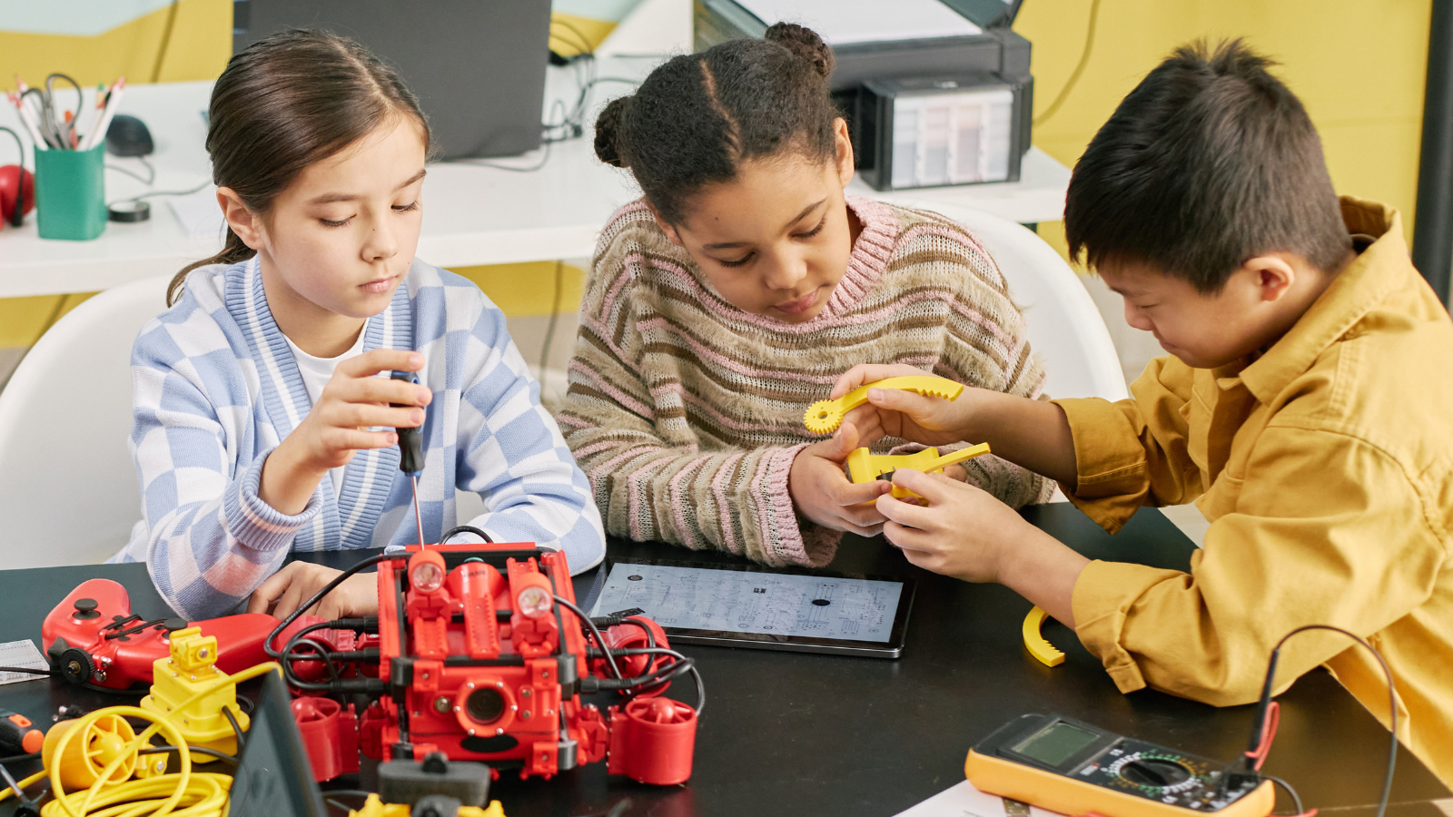 Kids working on STEM projects together in a group with robots