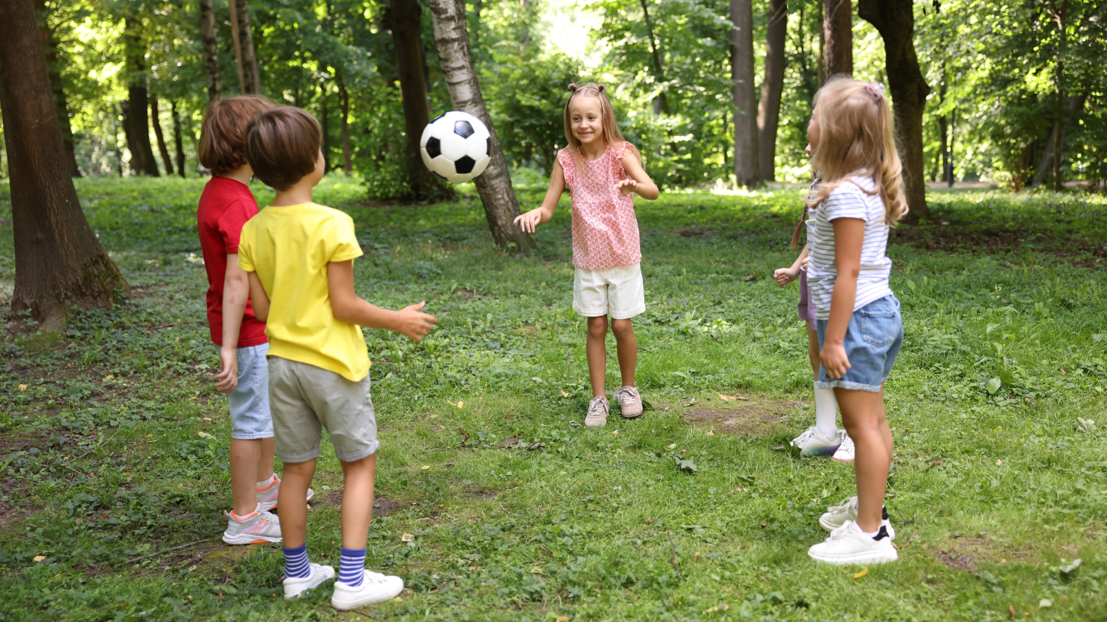 Kids playing games together out in the forest in the summertime
