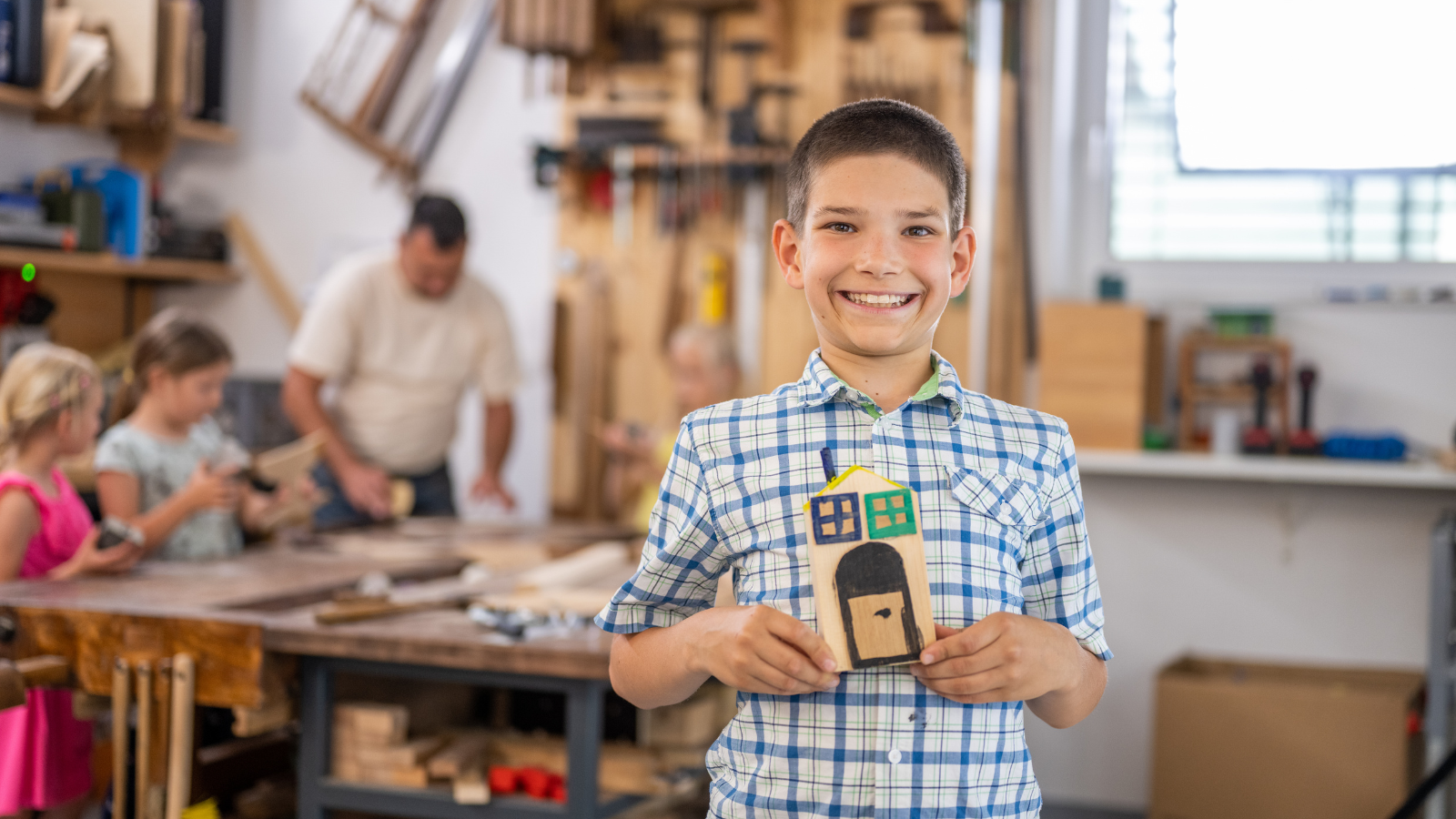 Kidpreneur smiles at the camera holding their craft.