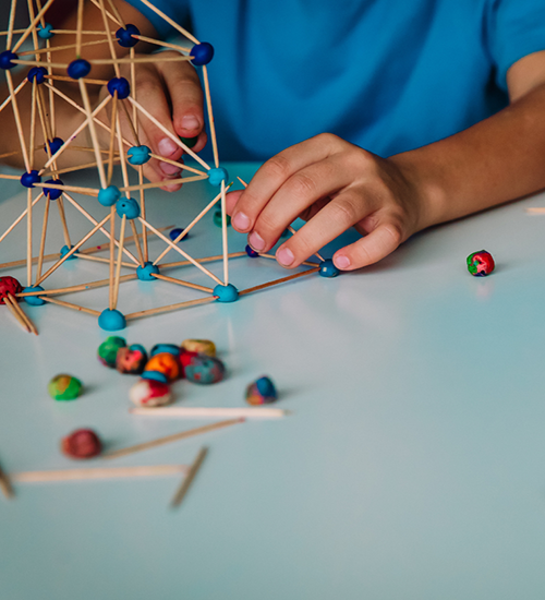 Children play with play-dough and sticks to build things